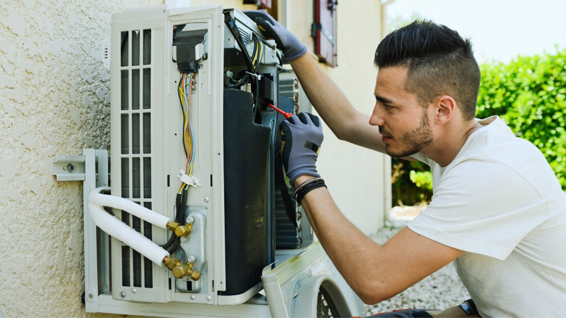 A professional technician providing AC repair service in Denham Springs, LA for a split-type air conditioner.